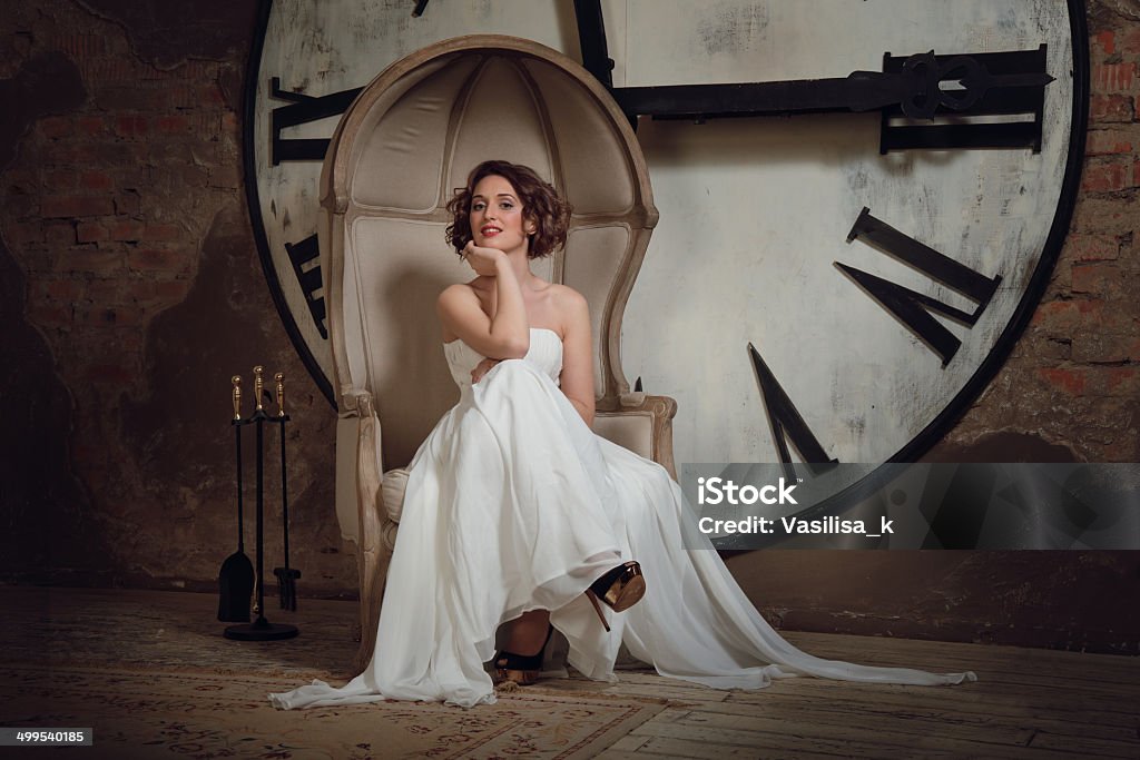Невеста на стул на фоне часы - Стоковые фото Женщины роялти-фри