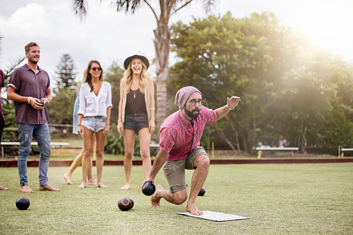 Group of Australian friends playing lawn bowling late in the afternoon.