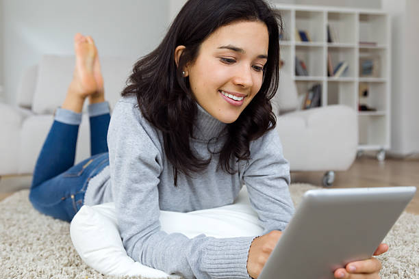 istock Beautiful young woman using her digital tablet at home. 499544332
