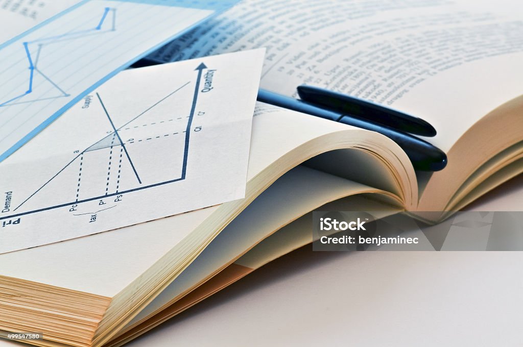 Learning a lesson Open textbook and pen. Economic book and chart. Diagram representing the dependence of economic parameters. Learning economy. 2015 Stock Photo