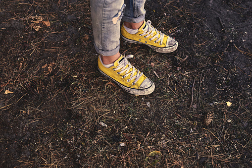 girl standing in the yellow shoes and jeans over
