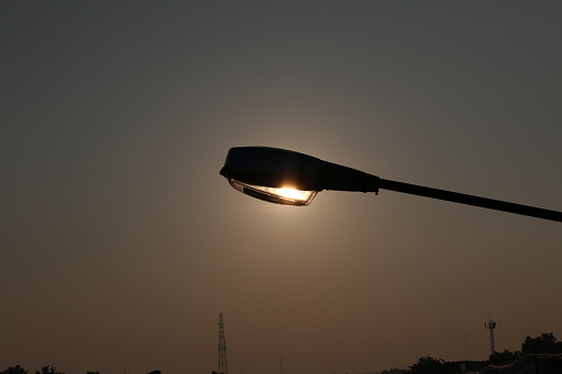 Silhouette light post during sun rise