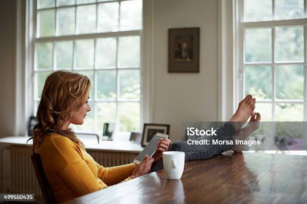 Woman Using Tablet While Relaxing In Cottage Stock Photo - Download Image Now - Digital Tablet, Reading, One Woman Only