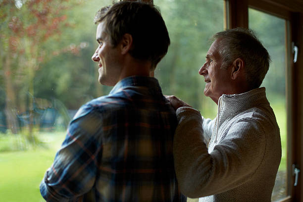 thoughtful father and son in cottage - senioren männer stock-fotos und bilder