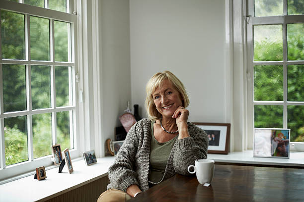 happy senior woman relaxing at table in cottage - 7002 뉴스 사진 이미지