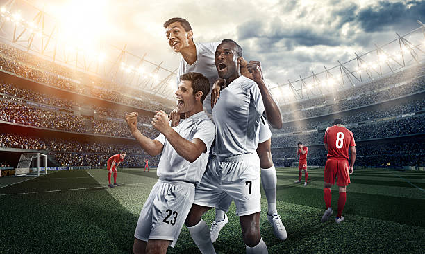 istock Three soccer players celebrate inside a stadium 499552091