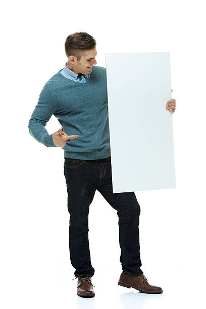 istock Young man standing with placard and pointing 499554197