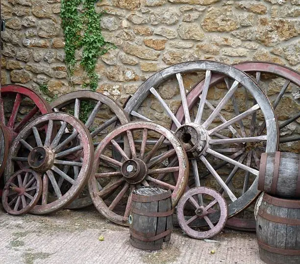 Wagon Wheels and Barrels against a wall at a cider farm in Somerset England