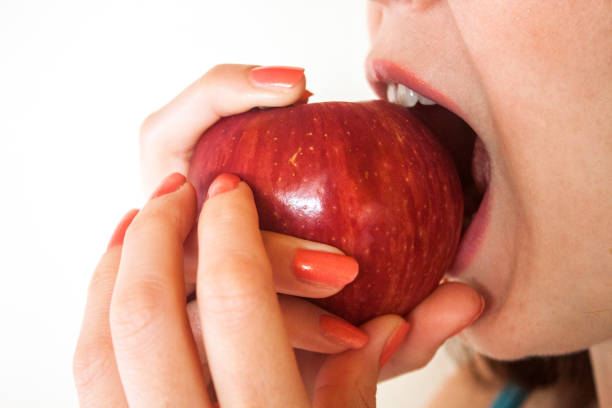 istock Woman biting big, red apple 499554581
