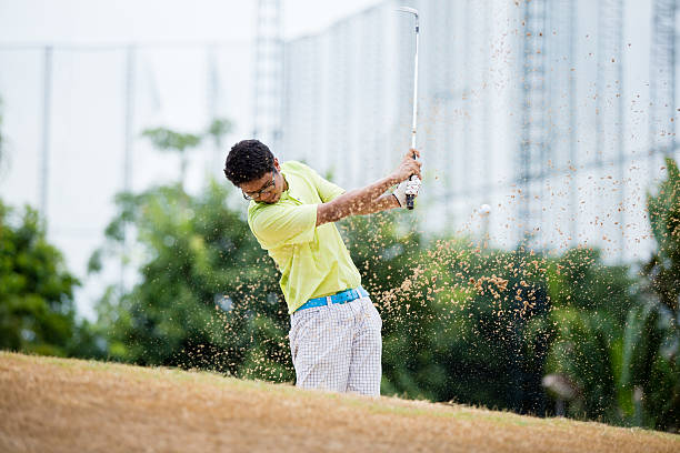 maschio golfista colpire palla da golf in un bunker di sabbia - golf swing golf golf club chipping foto e immagini stock