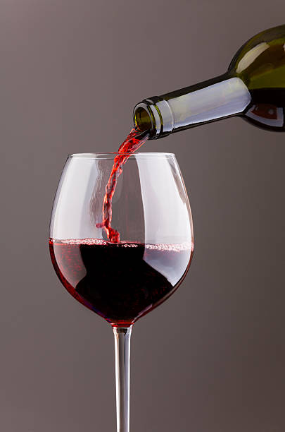 istock Wine pouring in glass on grey background 499556269