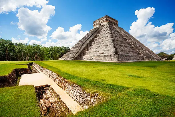 Monument of Chichen Itza on the green grass during summer in Mexico