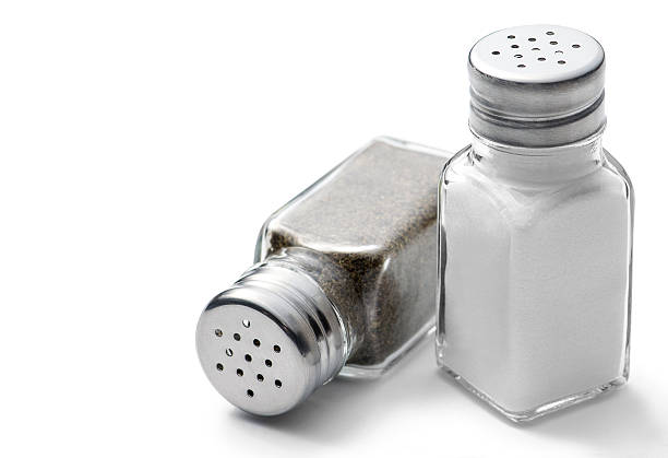 Salt & Pepper Salt and pepper shakers on a white background pepper shaker stock pictures, royalty-free photos & images