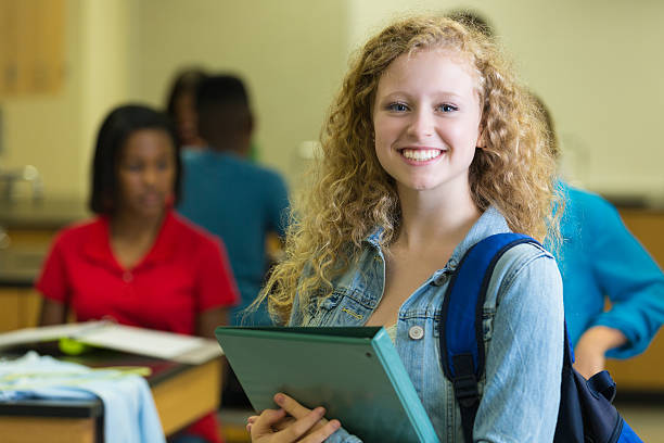 istock Cute high school age girl holding notebook in classroom 499565727