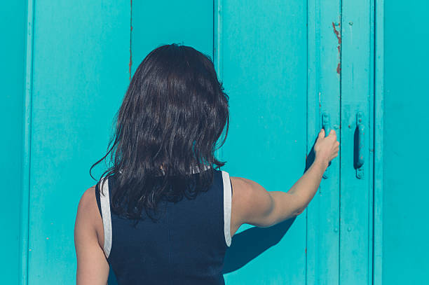 istock Young woman grabbing blue door 499567014