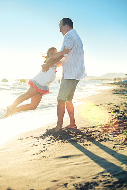 istock Father and daughter at beach 499568184
