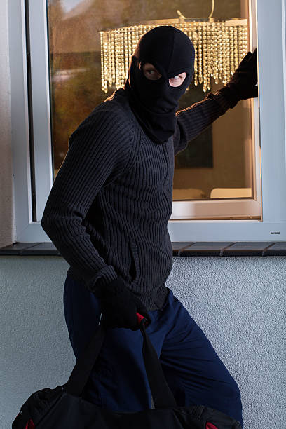 istock Burglar looks around and opening a window 499568843