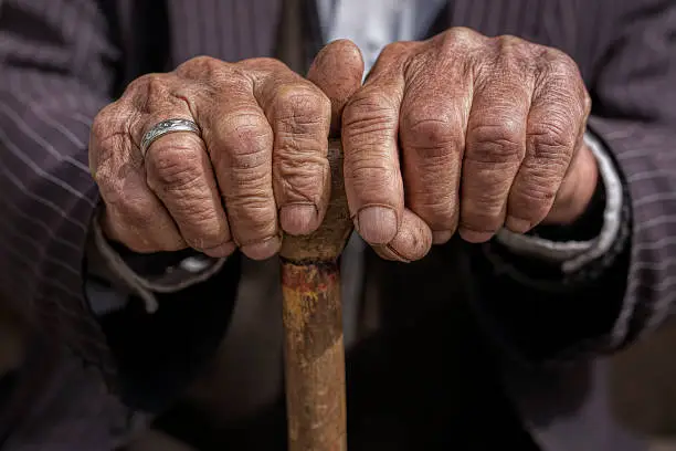 Photo of hand of a old man holding a cane