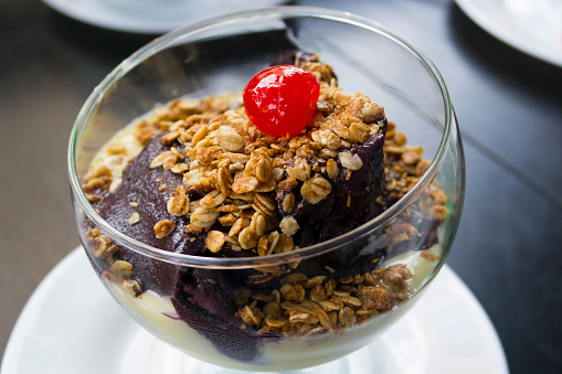 Bowl of Acai pulp with a cherry and granola. Acai or Açai is a tradicional berry from Amazon rainforest, Brazil.