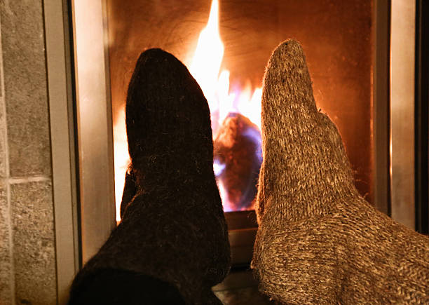 istock Feet in wool socks warming at the fireplace 499571664