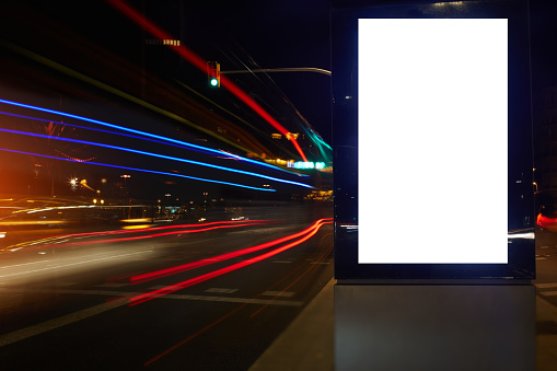 Blank billboard with copy space for your text message or promotional content, public information board in night city with shutter speed on background,