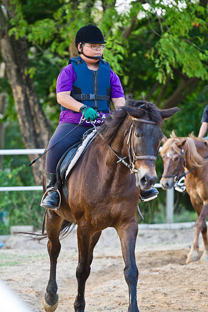 istock child trains horse riding , 499572179