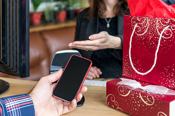 Man Paying With NFC Technology on Smart Phone in Store
