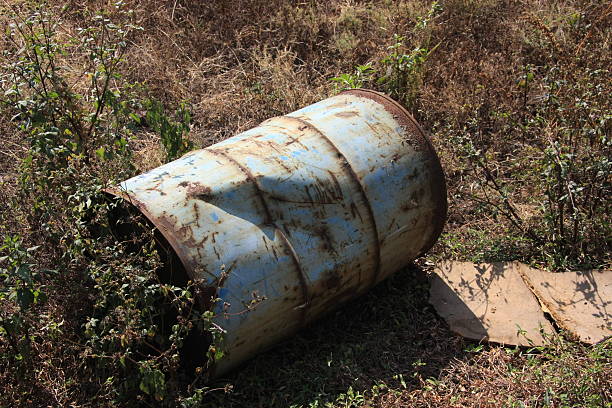 istock Old Damaged oil drum on ground 499577554