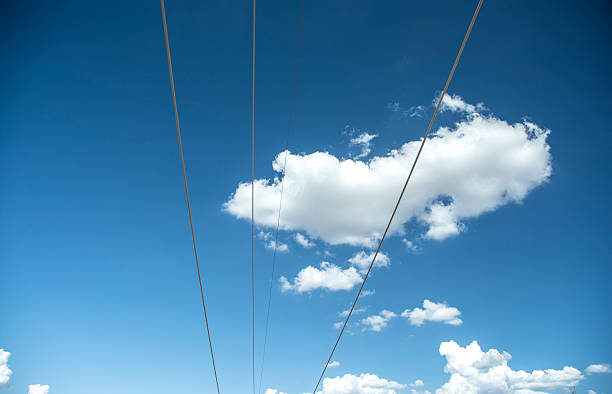 cables de teléfono powerline suspendida contra las nubes azules - phoneline fotografías e imágenes de stock