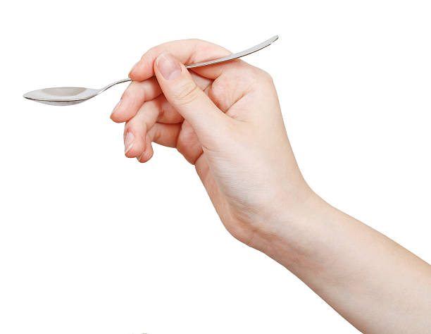 steel teaspoon in hand isolated on white steel teaspoon in hand isolated on white background tsp stock pictures, royalty-free photos & images