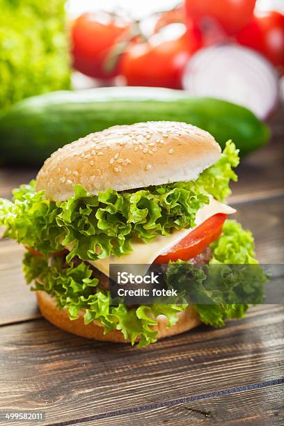 Cheeseburger Con Lechuga Y Tomate Cebolla En Un Nivel De Bun De Sésamo Foto de stock y más banco de imágenes de Alimento