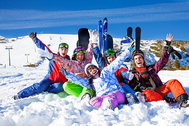 istock Friends with snowboards lifting hands up 499585009