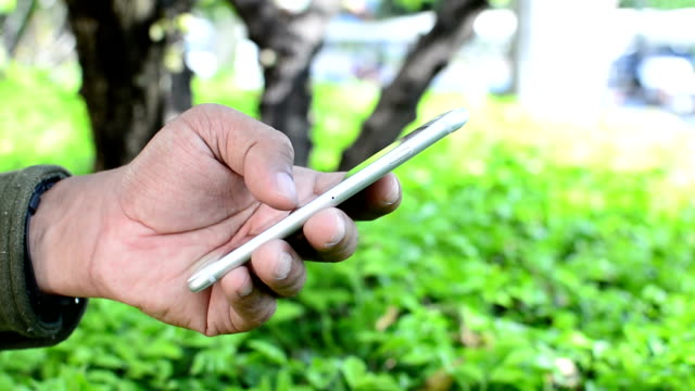 Close up of man using a smartphone in Garden