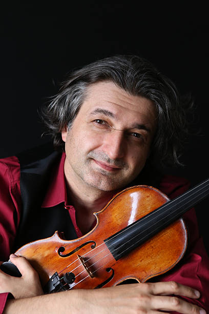 istock Violinist musician holding antique violin 499594424