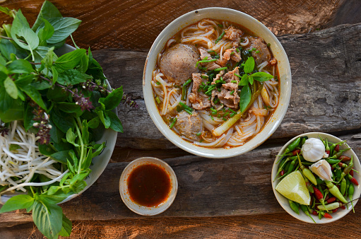 Pho Vietnamese beef soup on a wooden background