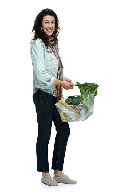 istock Happy young woman standing with shopping basket 499600247