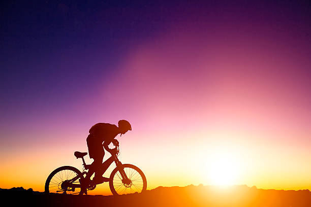 istock Man riding mountain bike with sunrise background 499600751