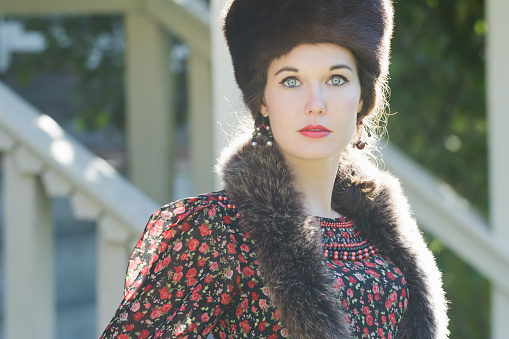 Head and shoulders portrait of Russian beautiful woman wearing fur Cossack hat and fur collar clothing