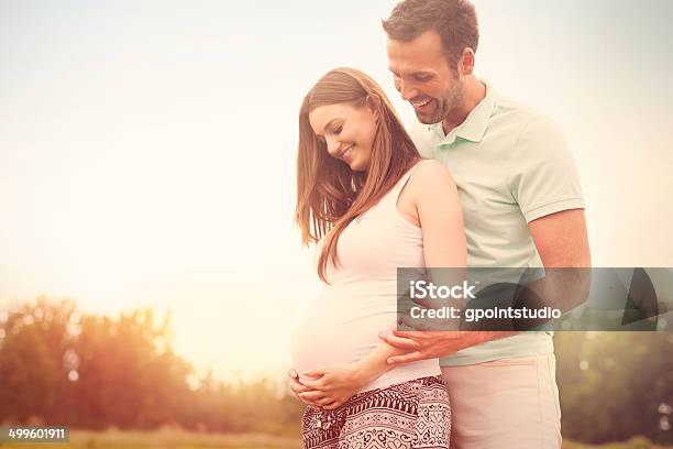 Portrait Of Lovely Future Parents During Sunset Stock Photo - Download Image Now - Pregnant, Two Parents, Couple - Relationship