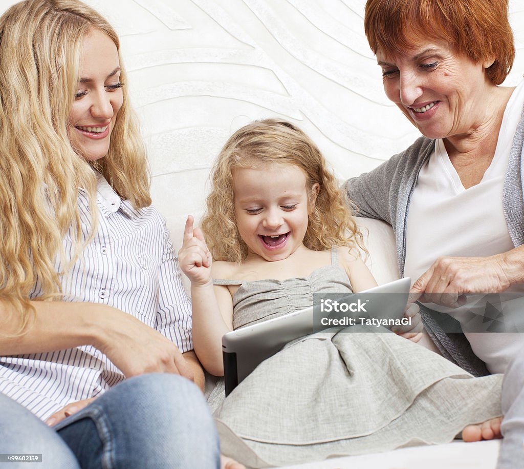 Familia tienen tableta en SOFÁ - Foto de stock de 50-59 años libre de derechos