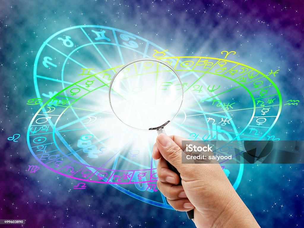 horoscope Hand  holding  magnifier the horoscope concept. 2015 Stock Photo