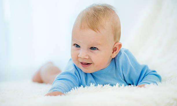 istock Smiling baby lying on white blanket. 499607584