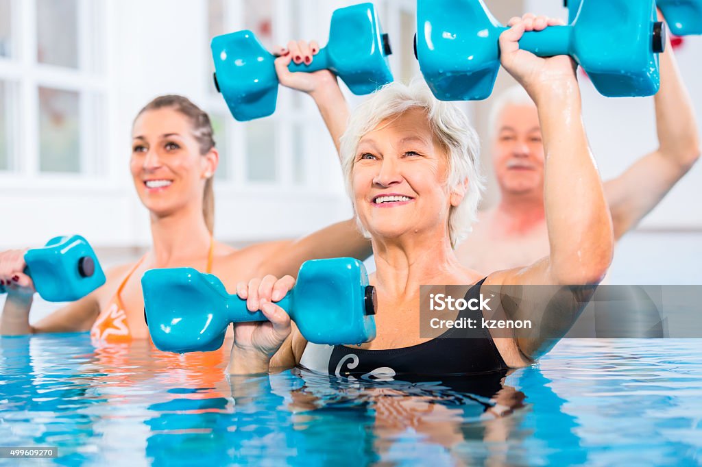 People at water gymnastics in physiotherapy People young and senior in water gymnastics physiotherapy with dumbbells Water Aerobics Stock Photo