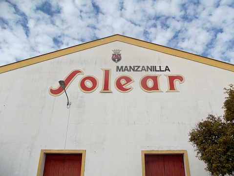 Sanlucar de Barrameda, Spain - December 2, 2015: Solear Manzanilla Brewery signage on a cloudy blue sky.