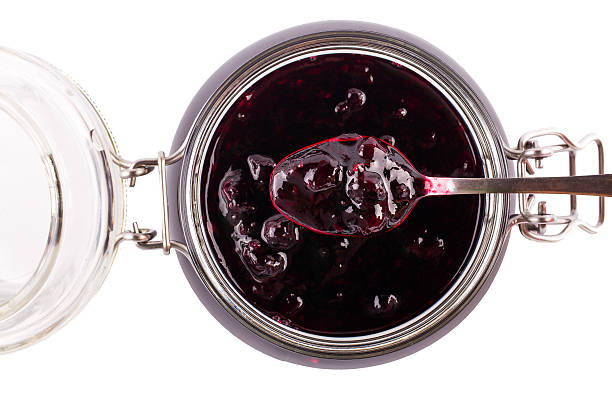 istock Spoon of jam from currant over a can on a 499609728