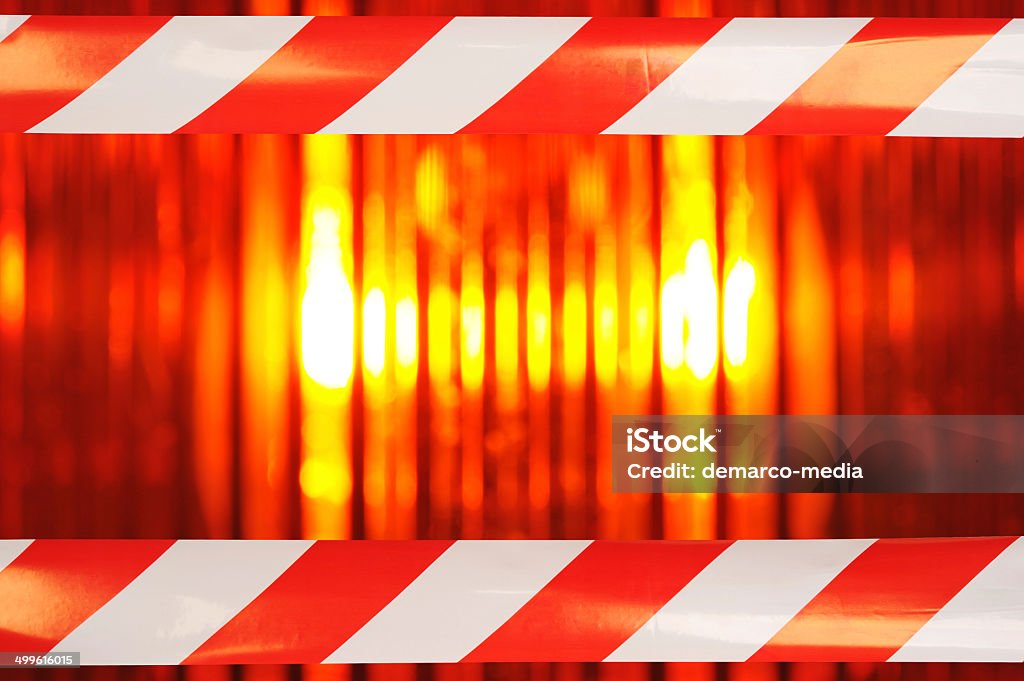 beacon light with barrier tape building lot background with macro detail of an orange beacon light with two barrier tapes Amber Light Stock Photo