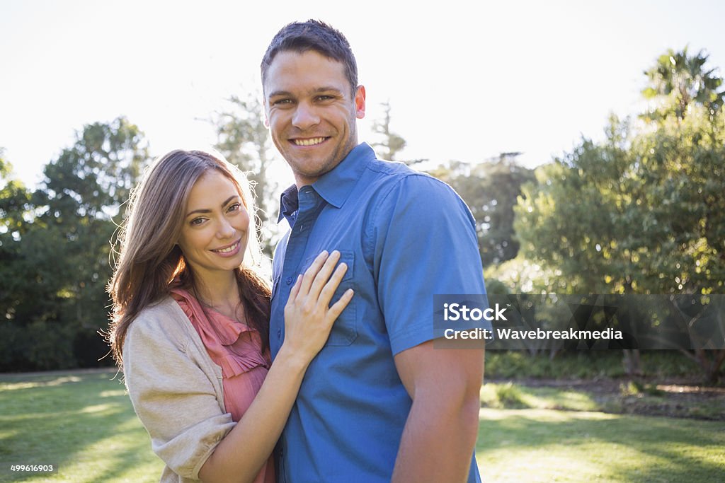 Smiling couple standing in a park Smiling couple standing in a park with trees 30-39 Years Stock Photo