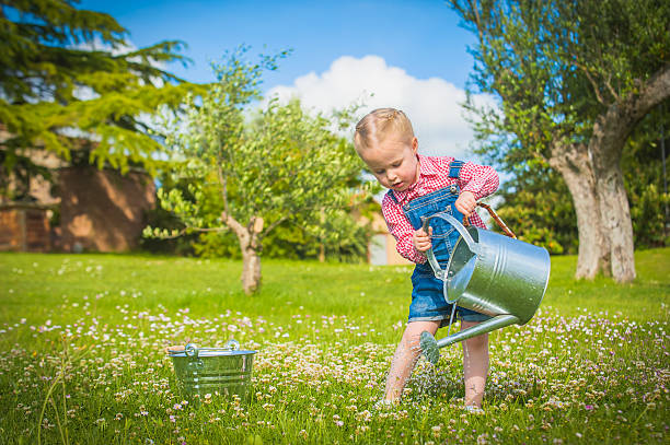 istock Little gardiner on the green grass in a summer day 499617063