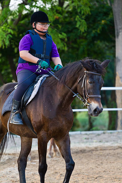 istock child trains horse riding , 499617881