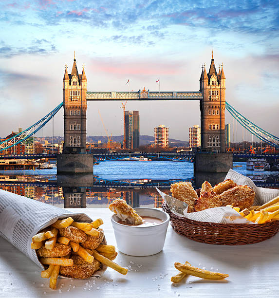 Fish and Chips against Tower Bridge in London, England Typical food Fish and Chips against Tower Bridge in London, England drawbridge photos stock pictures, royalty-free photos & images
